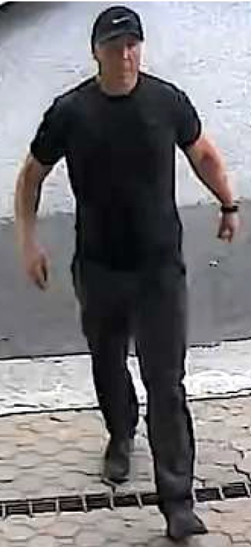 Front view of a man wearing a black hat, black short sleeved t-shirt, black pants and black shoes.